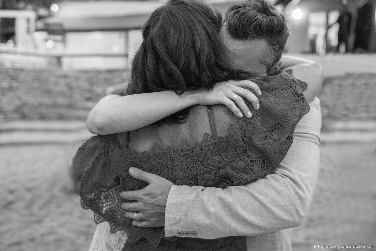 foto dos noivos e mãe da noiva se abraçando 