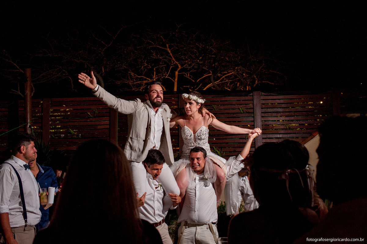 foto dos noivos nas costas dos convidados dançando na festa de casamento no club la plage