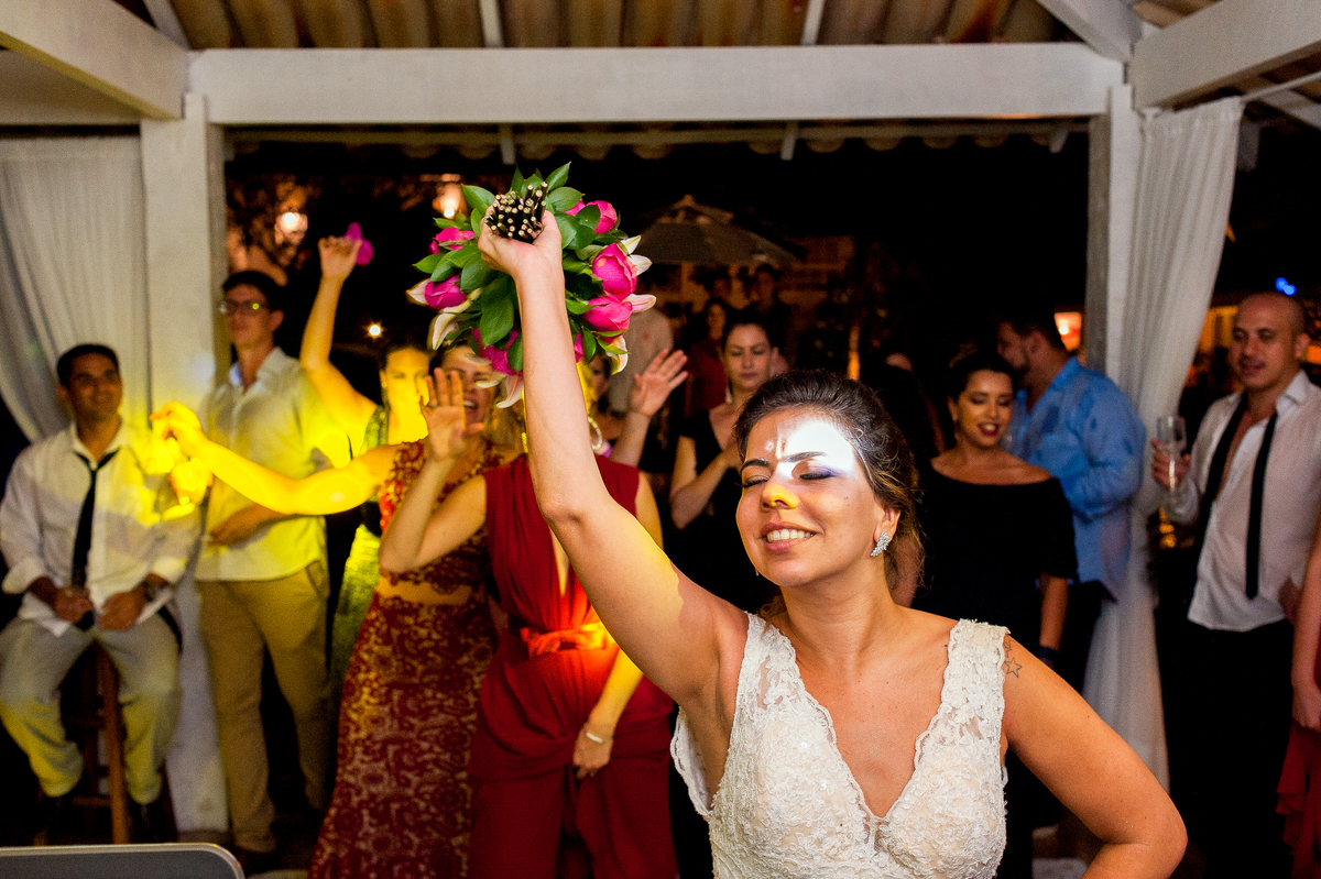imagem de noiva jogando o bouquet em festa de casamento na pousada bucanero em búzios rio de janeiro
