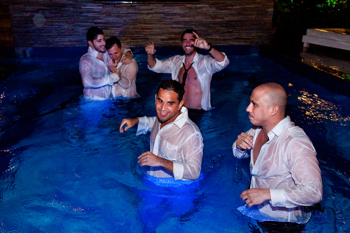 imagem do noivo com padrinhos e convidados na piscina em festa de casamento na pousada bucanero em búzios rio de janeiro
