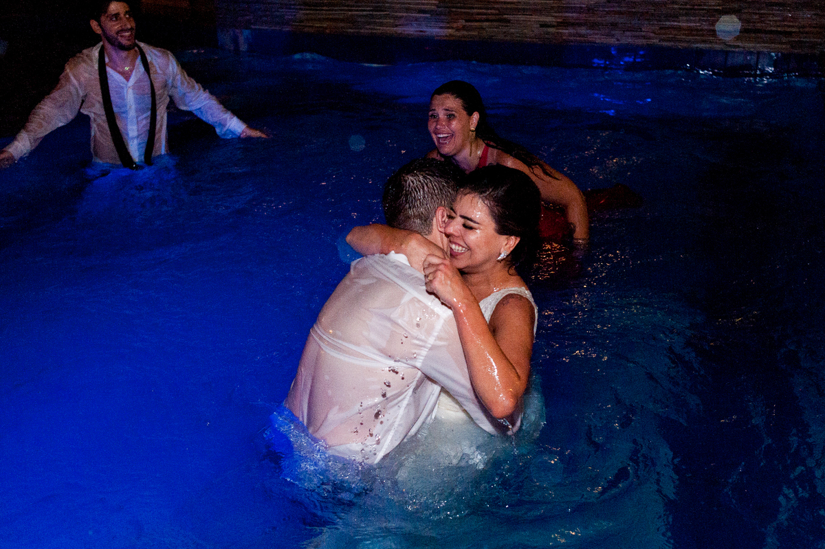 imagem dos noivos com convidados na piscina em festa de casamento na pousada bucanero em búzios rio de janeiro
