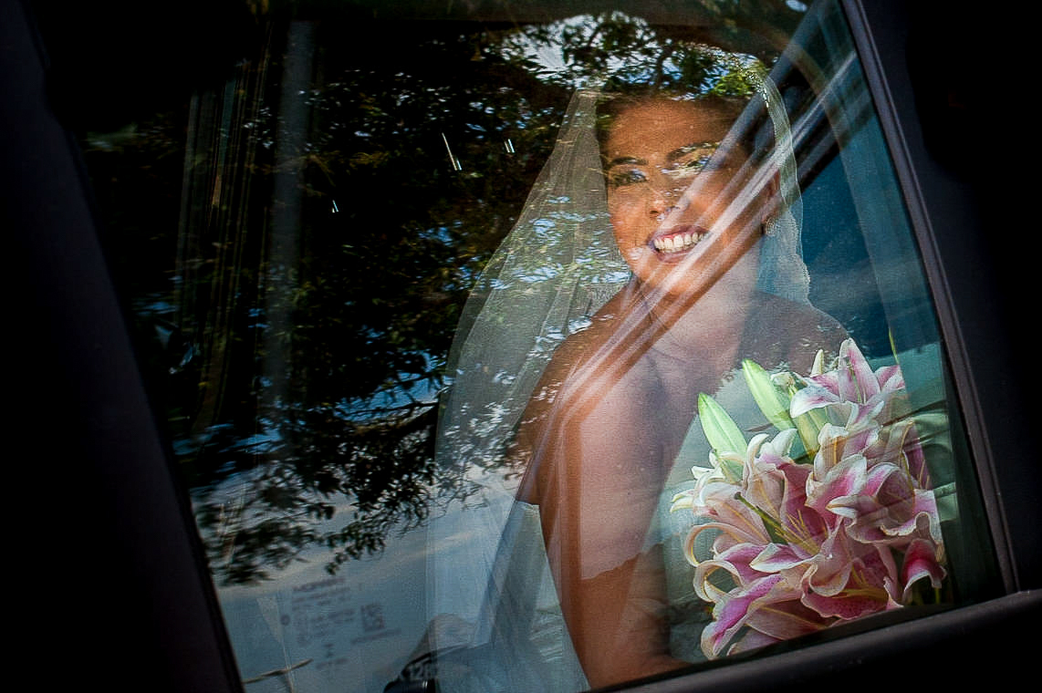 fotografia da noiva chegando no carro para casamento de dia na paróquia são francisco xavier em niterói rio de janeiro