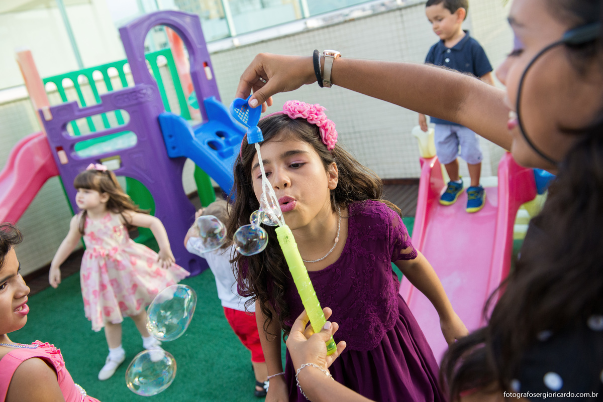 crianças brincando com bolinha de sabão em festa infantil