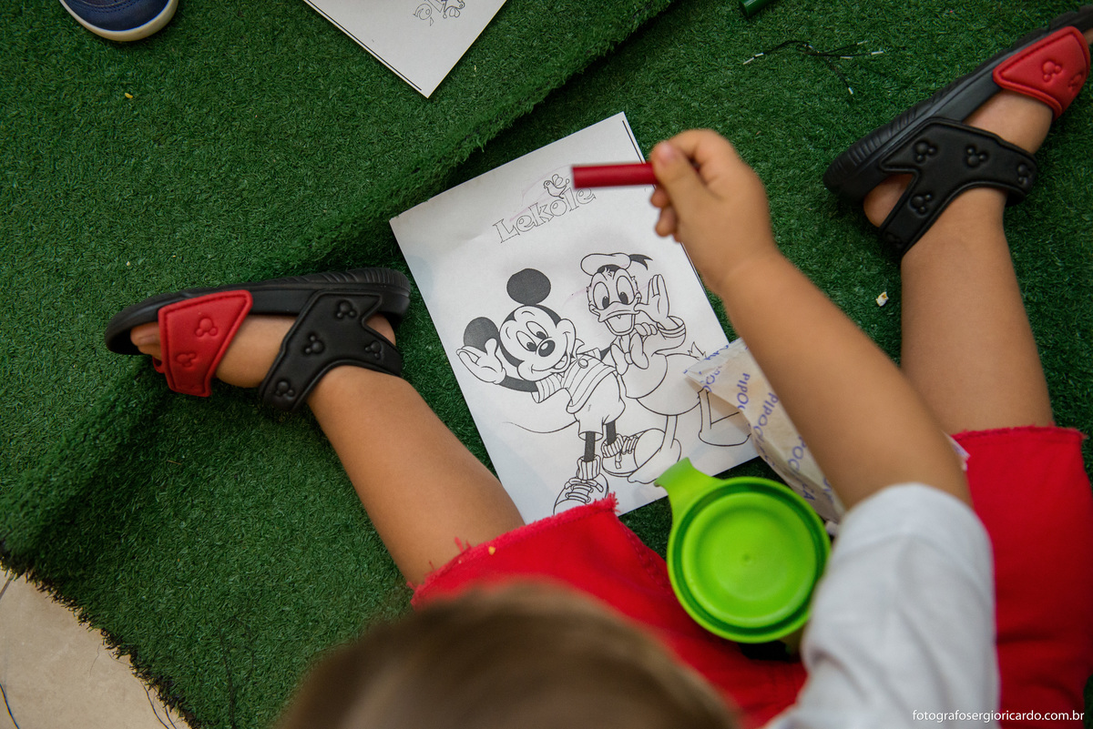 criança pintando com giz de cera em festa infantil