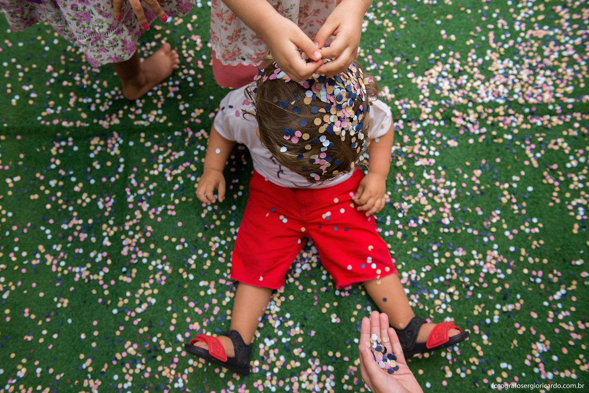 aniversariante brincando com confete em festa infantil