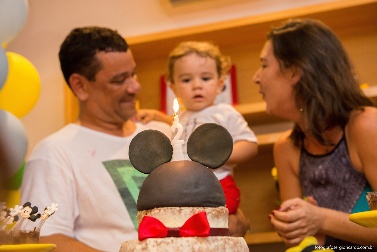 criança na mesa do bolo com tema do mickey