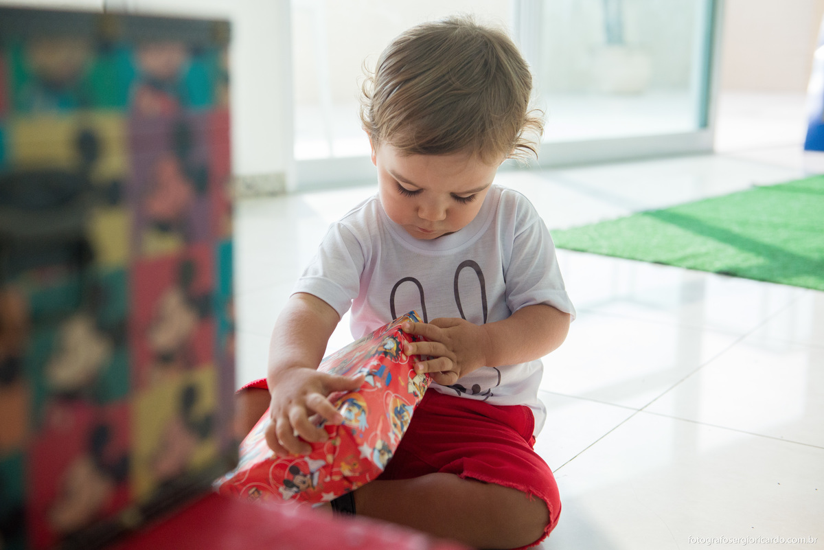 criança abrindo seu presente de aniversário
