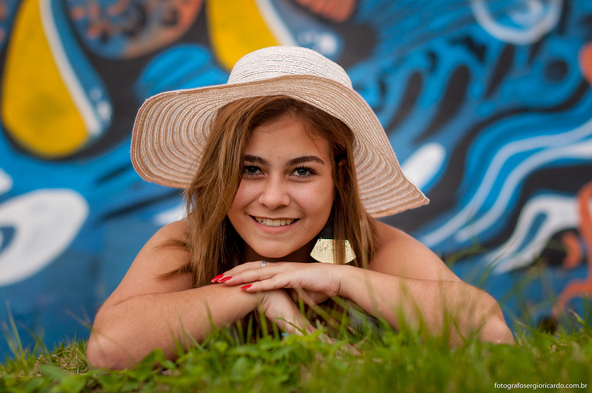 aniversariante deitada com chapéu na praia da joatinga 