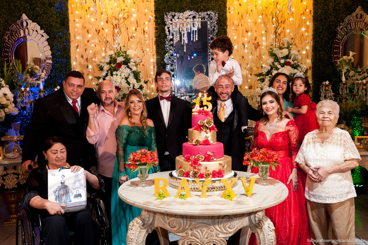 fotografia do parabéns da debutante com a família ao lado do bolo