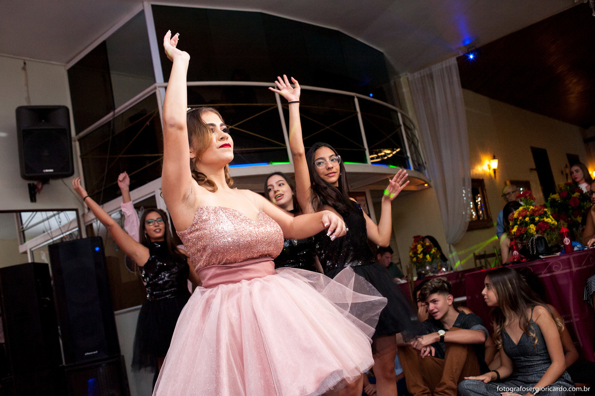 imagem da debutante dançando com as amigas em casa de festas