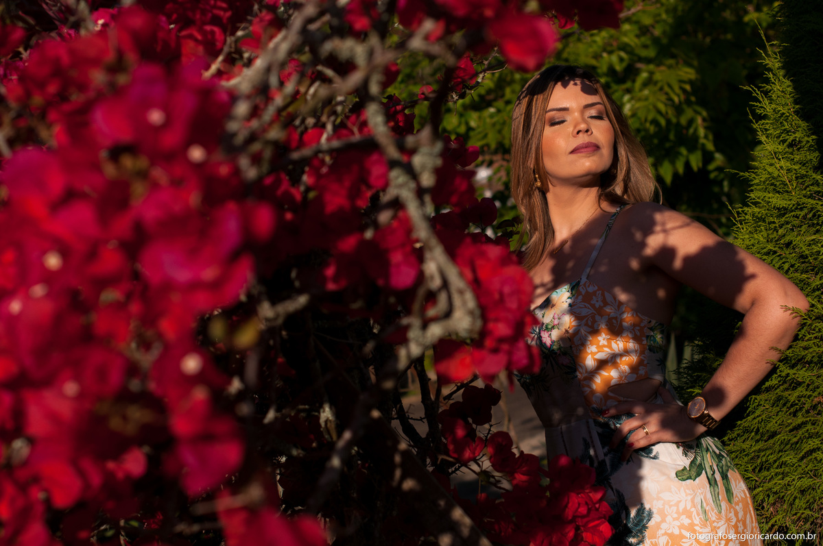 ensaio feminino em foto no jardim com flores vermelhas