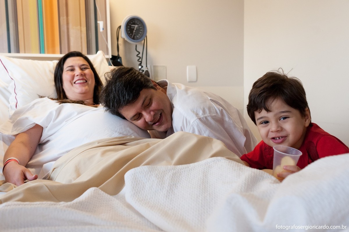 Fotografia da mãe com a família no quarto da Perinatal Barra aguardando o parto