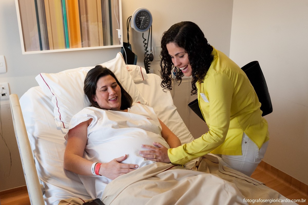 Foto da mãe com a família no quarto da Perinatal Barra aguardando o parto