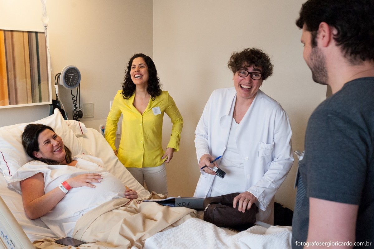 Foto dos pais com a obstetra e anestesista no quarto da Perinatal Barra aguardando o parto