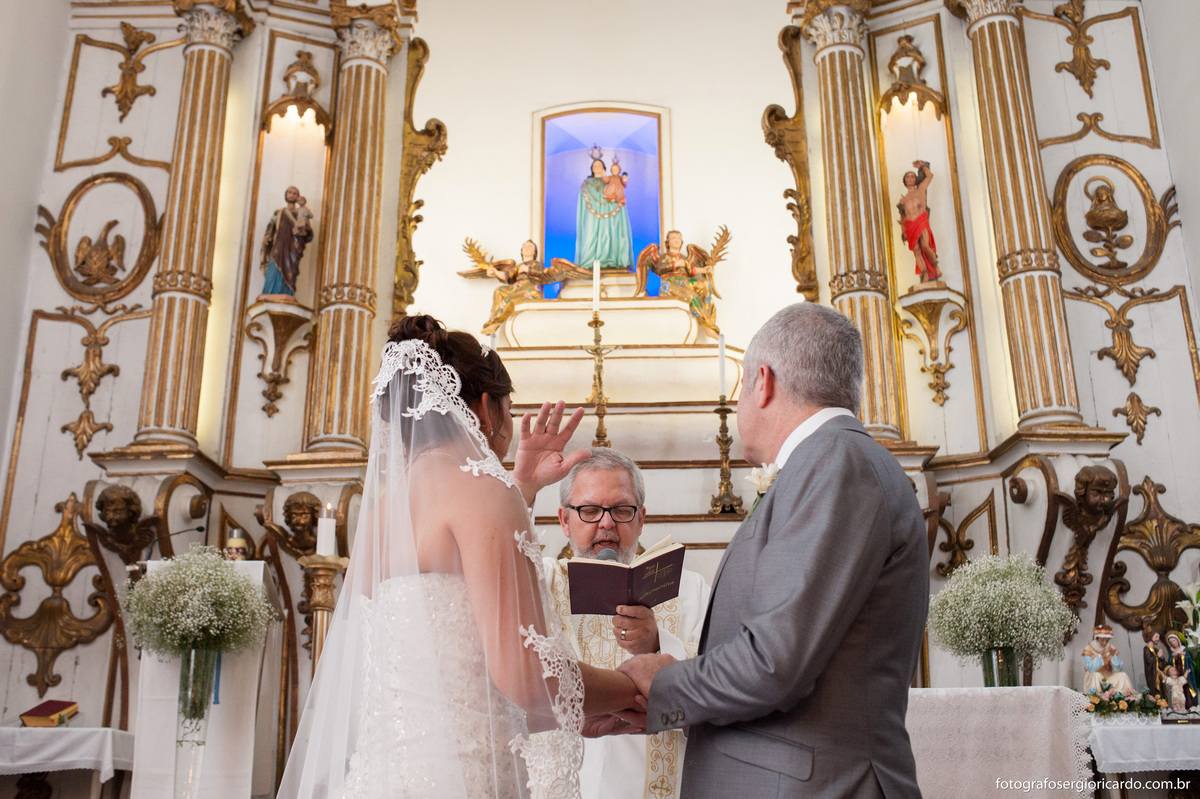 fotografia do casal de noivos recebendo a benção de Deus durante o casamento na igreja nossa senhora do loreto