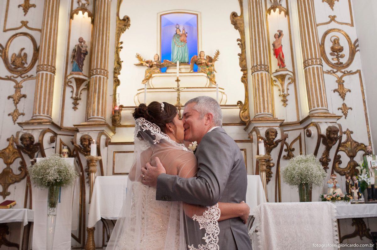 foto do beijo dos noivos no altar durante o casamento na igreja nossa senhora do loreto na freguesia rio de janeiro