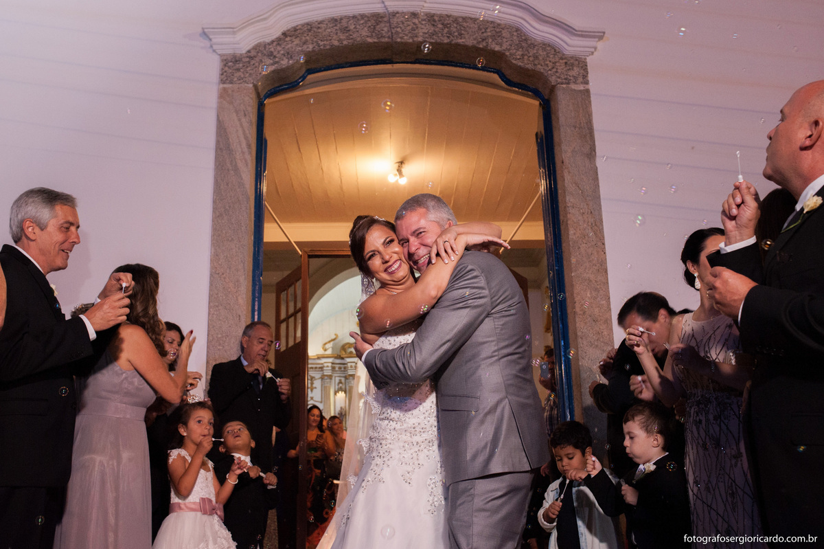 foto dos noivos se abraçando na porta da igreja nossa senhora do loreto após o casamento