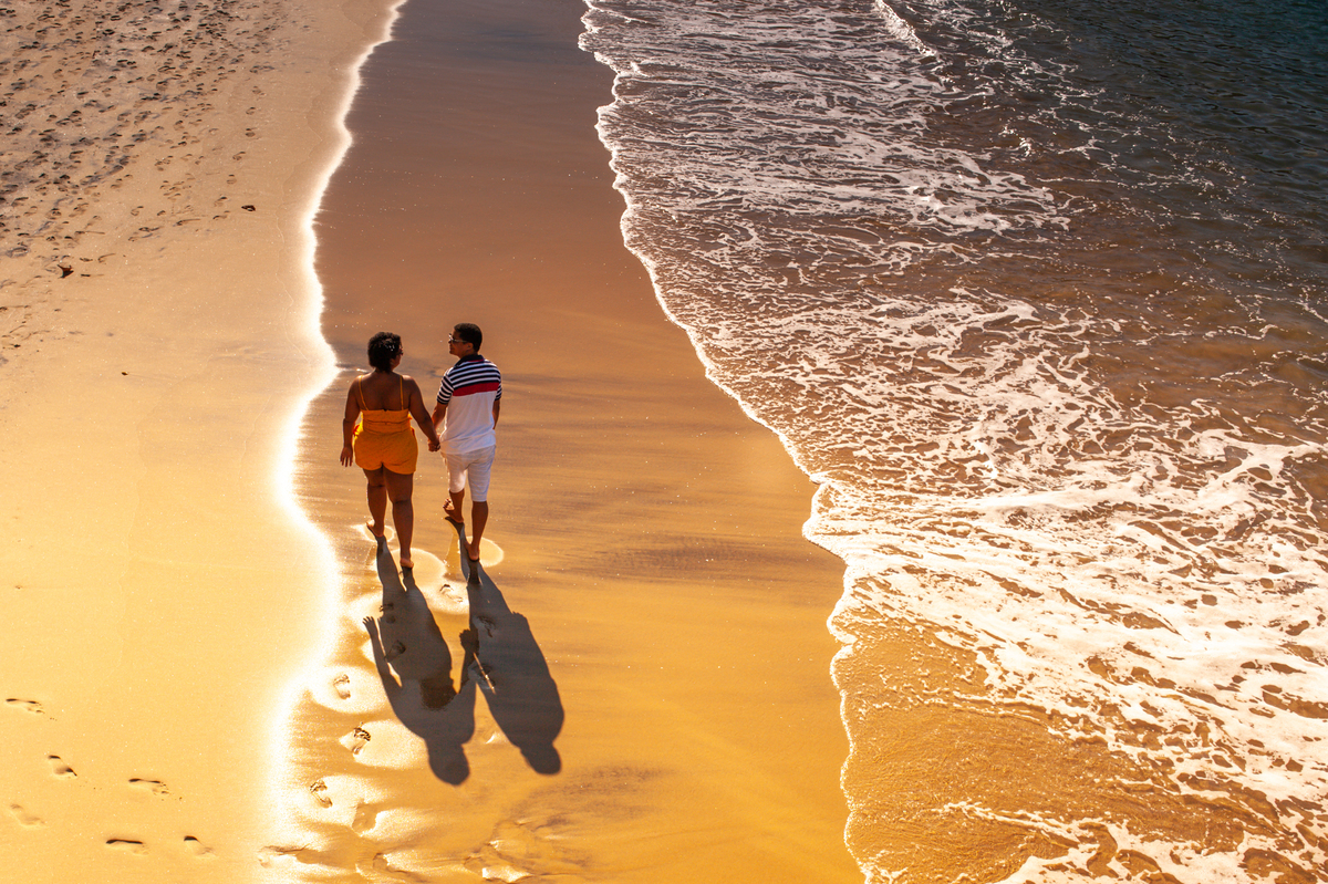 Ensaio fotográfico de casal caminhando na praia em Angra dos Reis vista do Hotel Angra Inn no Rio de Janeiro