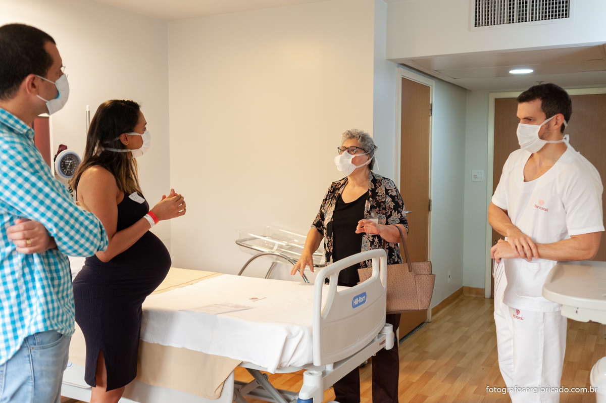 Foto dos pais com a obstetra e anestesista no quarto da Perinatal Barra aguardando o parto