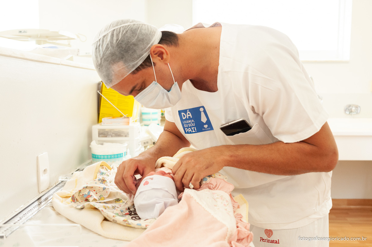 Fotografia do pai com a filha recém-nascida no berçário da Perinatal da Barra no Rio de Janeiro