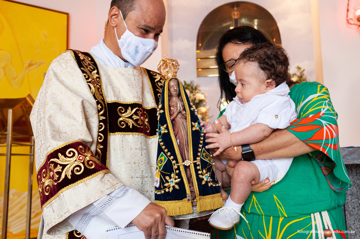 Fotografia da madrinha de consagração com criança durante cerimônia do batismo na Capela de Nossa Senhora Aparecida no Cristo Redentor localizado no Morro do Corcovado no Rio de Janeiro
