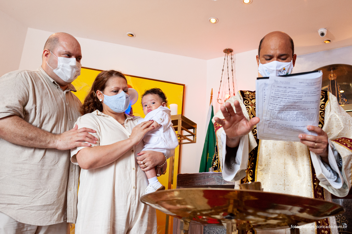 Foto da criança recebendo o batismo na Capela de Nossa Senhora Aparecida no Cristo Redentor localizado no Morro do Corcovado no Rio de Janeiro