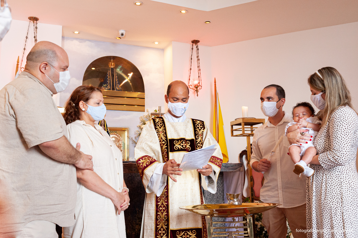 Fotografia dos pais com o padre e padrinhos realizando cerimônia de batismo na Capela de Nossa Senhora Aparecida no Cristo Redentor localizado no Morro do Corcovado no Rio de Janeiro