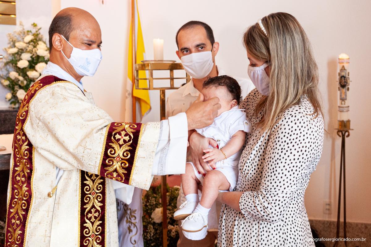 Fotografia dos padrinhos com criança recebendo o batismo na Capela de Nossa Senhora Aparecida no Cristo Redentor localizado no Morro do Corcovado no Rio de Janeiro