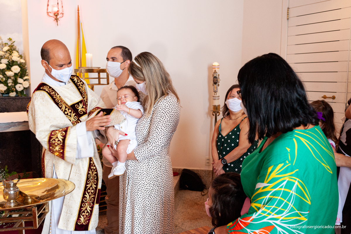 Fotografia dos padrinhos e convidados com criança recebendo o batismo na Capela de Nossa Senhora Aparecida no Cristo Redentor localizado no Morro do Corcovado no Rio de Janeiro