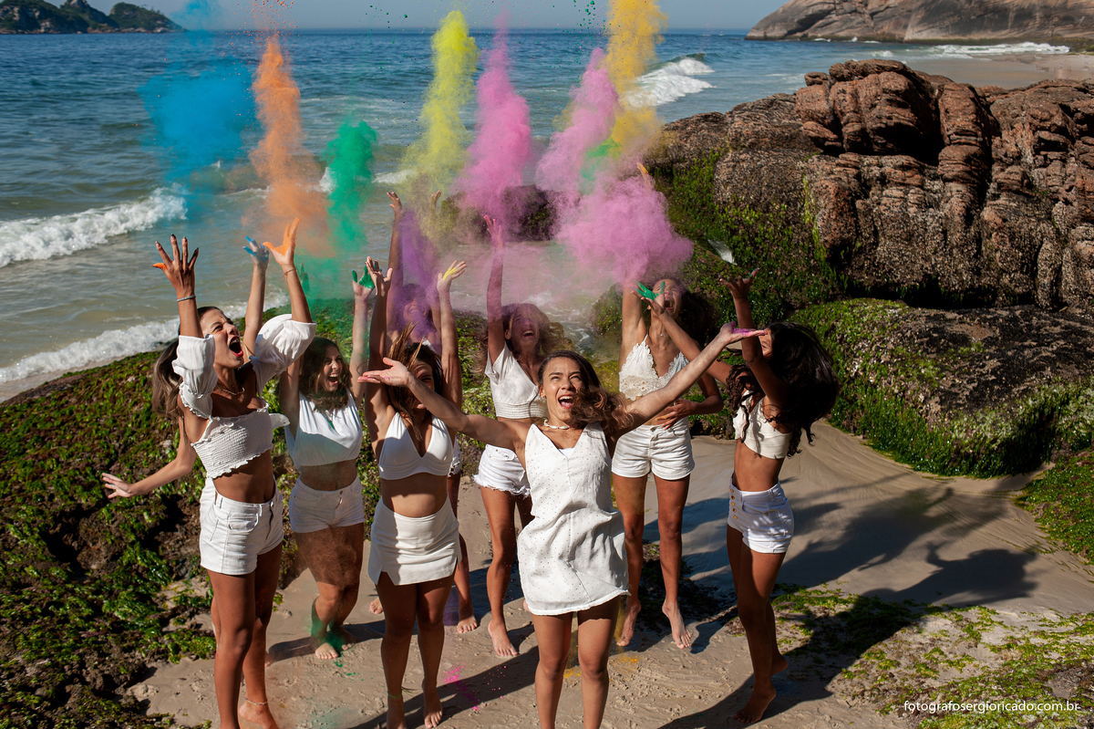foto de ensaio de 15 anos com as amigas brincando com pó colorido na praia da joatinga no rio de janeiro