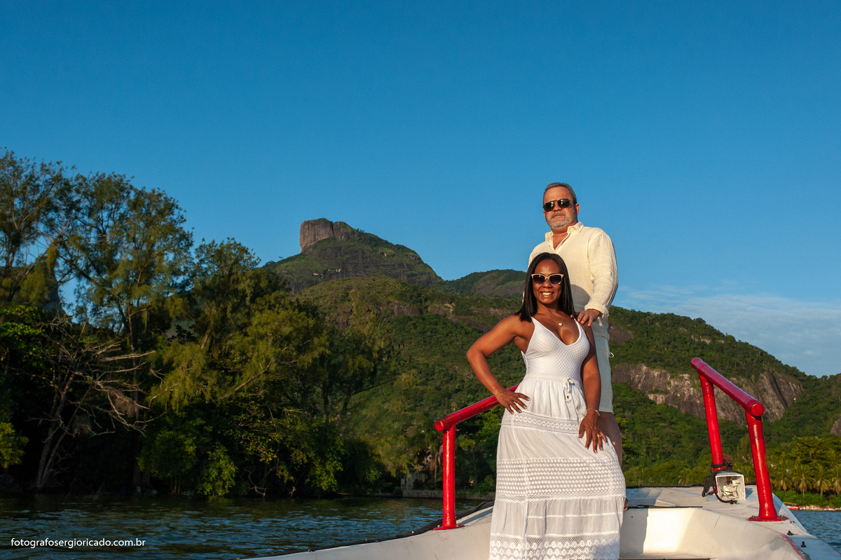 Fotografia de ensaio de casal em passeio de barco pela Ilha da Gigóia com paisagem da Pedra da Gávea na Barra da Tijuca no Rio de Janeiro