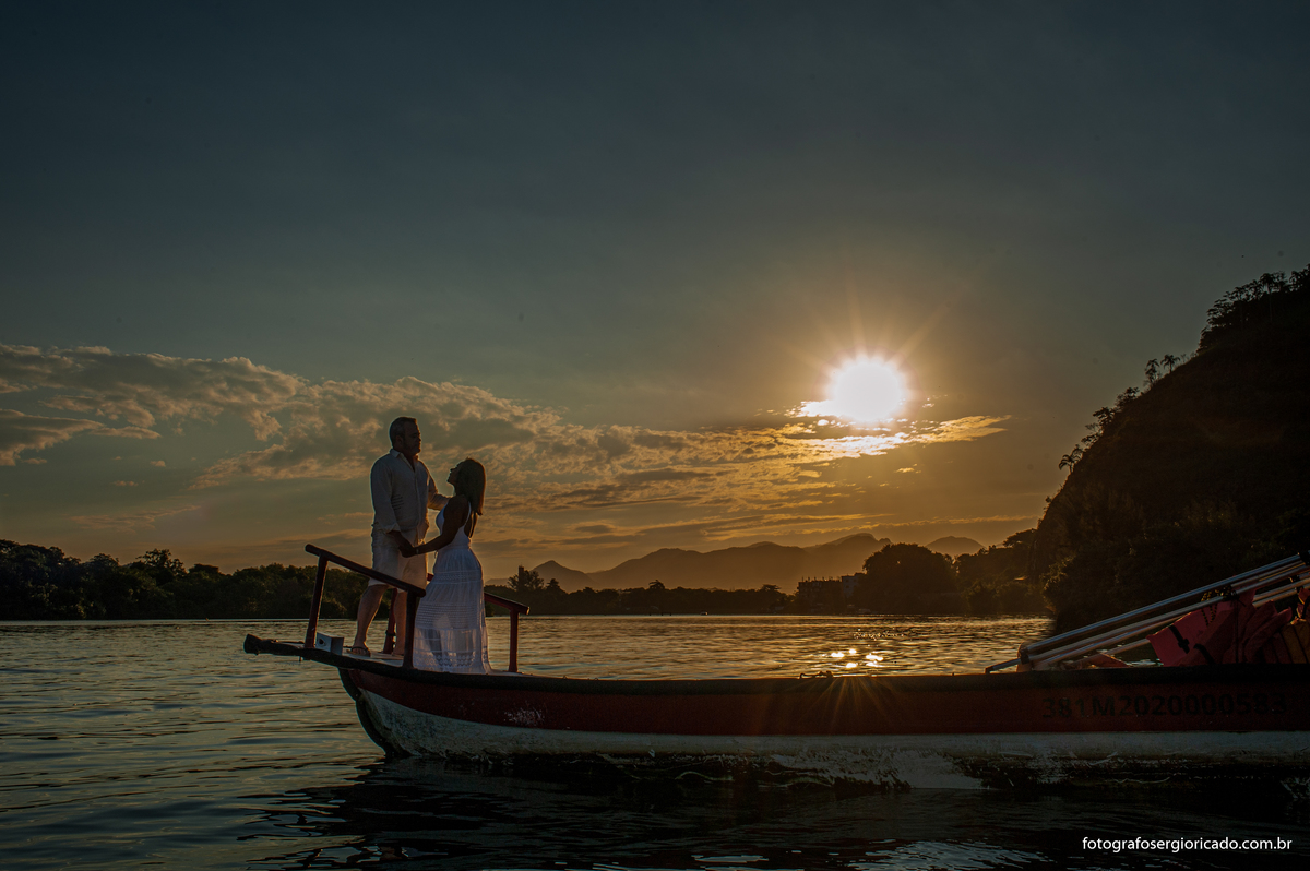 Fotografia de ensaio de casal em passeio de barco pela Ilha da Gigóia com pôr do sol na Barra da Tijuca no Rio de Janeiro