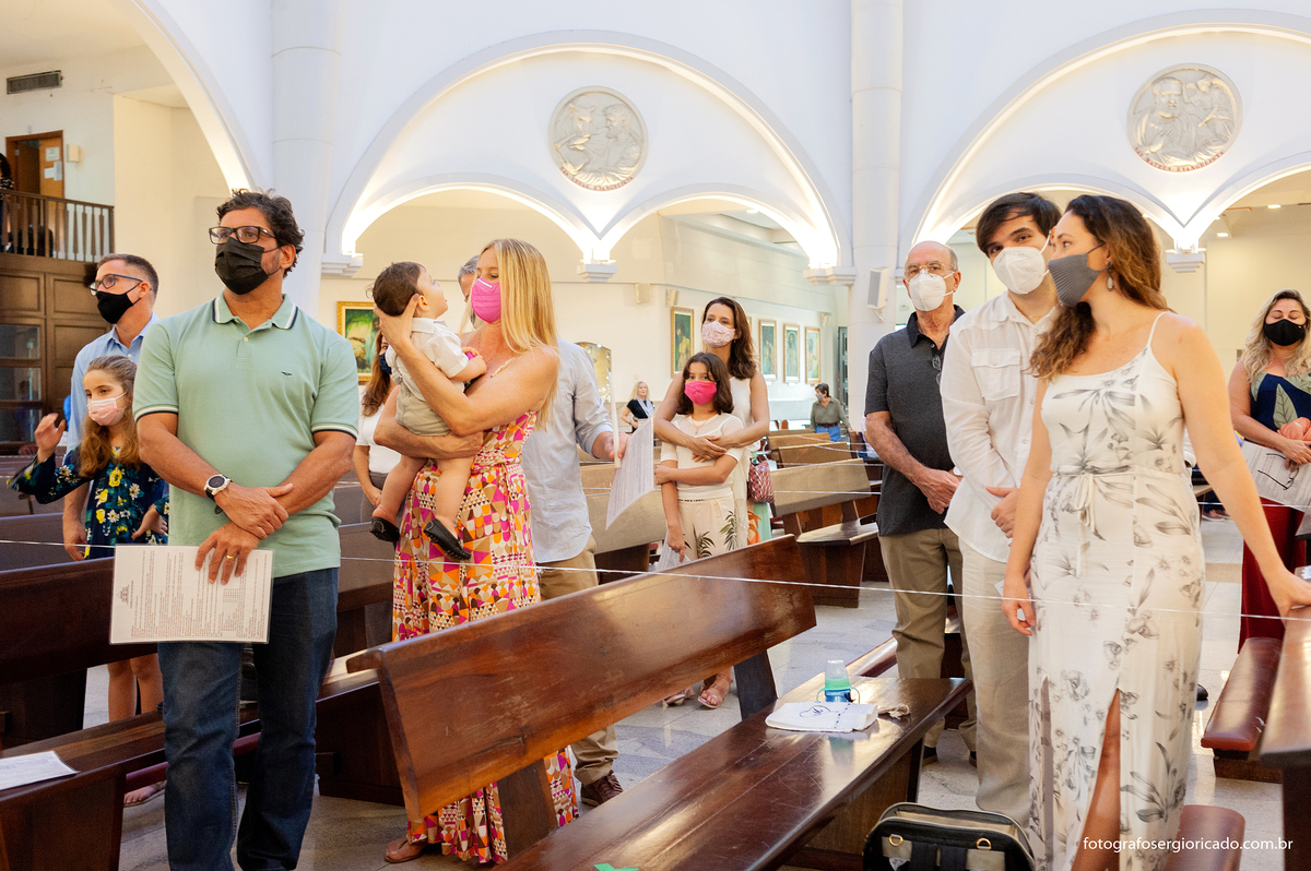 Imagem dos pais e convidados durante o rito do batismo na Paróquia São Francisco de Paula na Barra da Tijuca no Rio de Janeiro