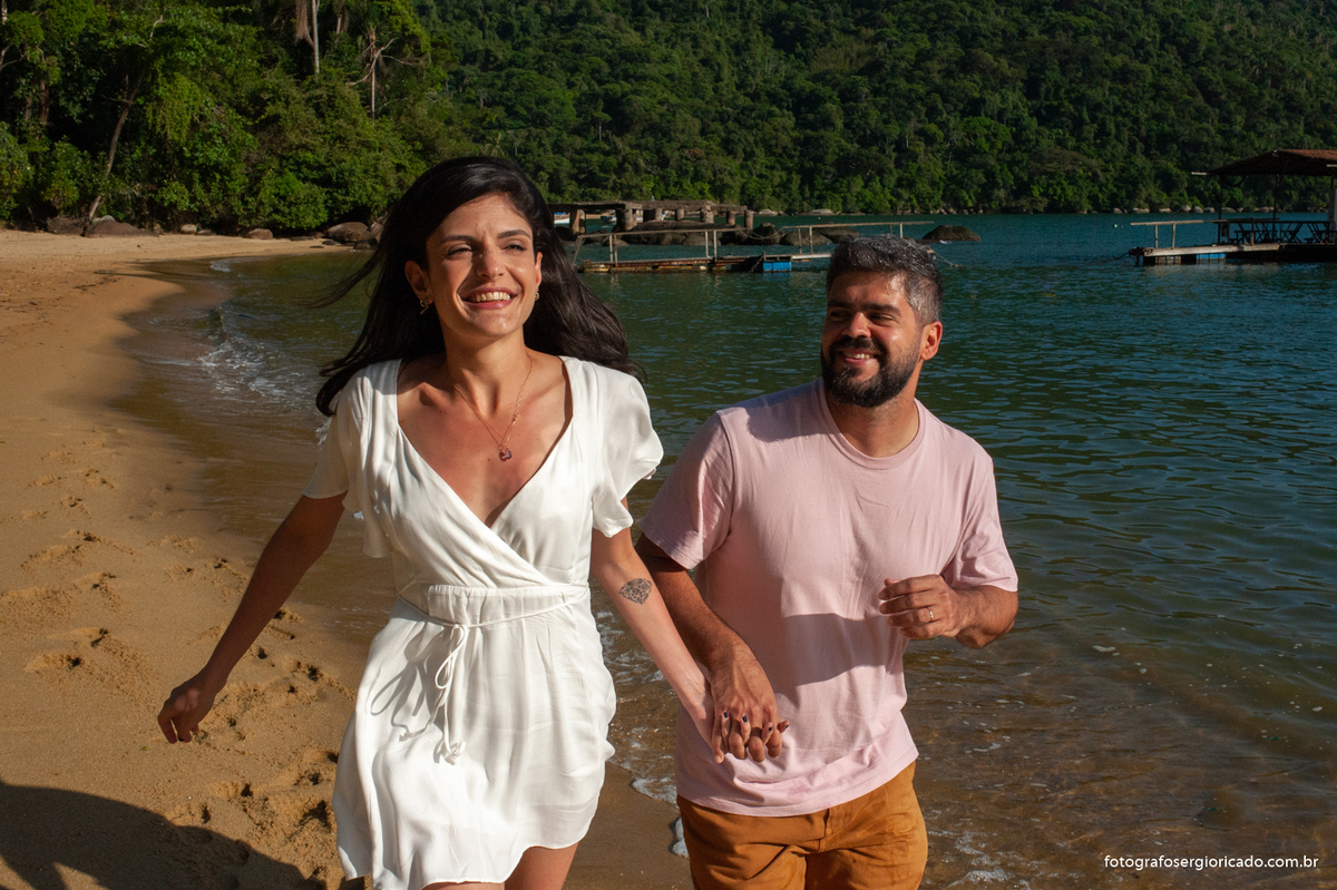 Fotografia de ensaio de casal correndo na Praia do Pouso na Ilha Grande, Angra dos Reis no Rio de Janeiro.