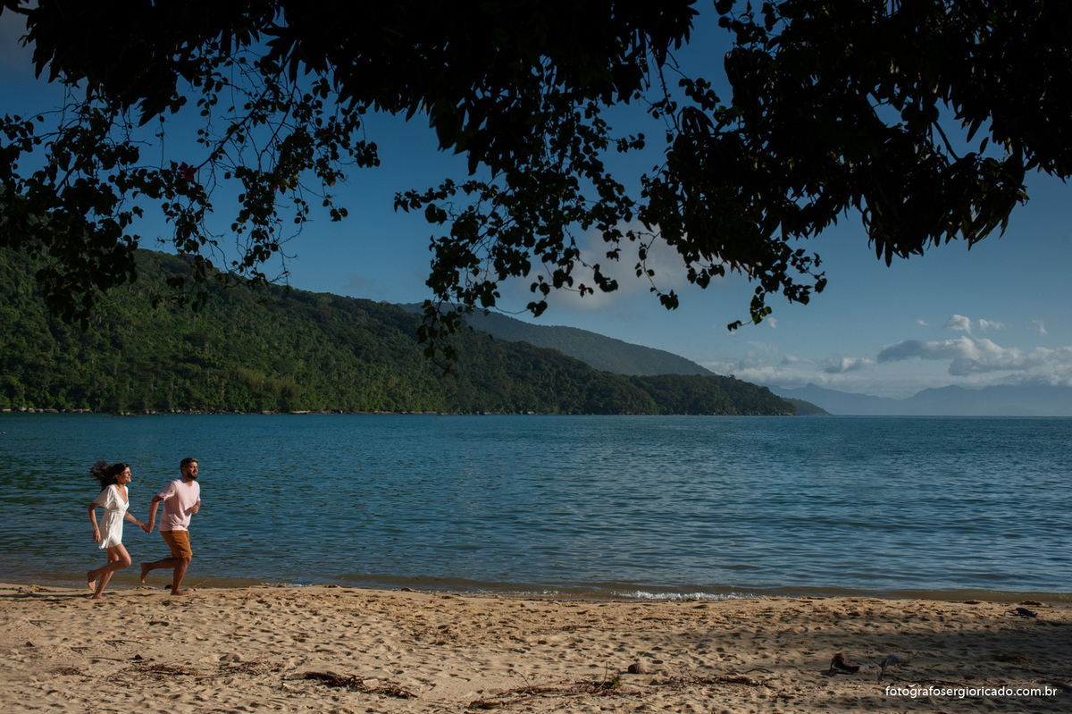 Fotografia de ensaio de casal correndo na Praia do Pouso na Ilha Grande, Angra dos Reis no Rio de Janeiro.