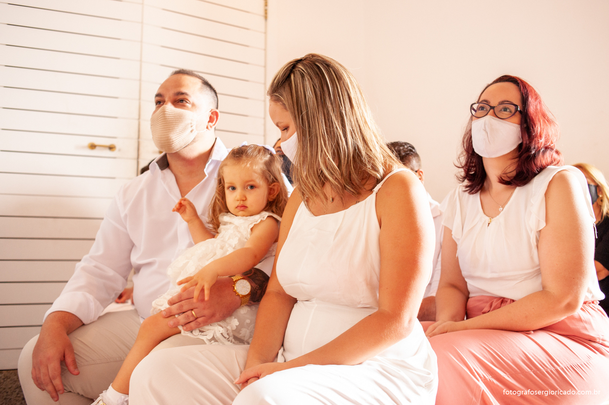 Fotografia dos pais e padrinhos com criança na cerimônia de batismo na Capela de Nossa Senhora Aparecida no Cristo Redentor localizado no Morro do Corcovado no Rio de Janeiro