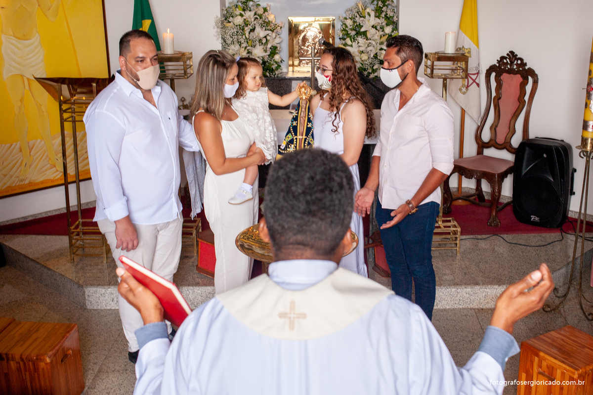 Foto dos pais com o padre e os padrinhos realizando cerimônia de batismo na Capela de Nossa Senhora Aparecida no Cristo Redentor localizado no Morro do Corcovado no Rio de Janeiro