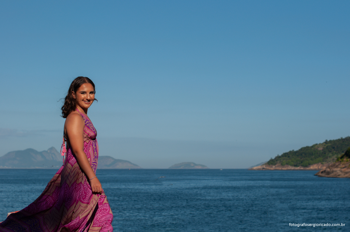 fotografia do ensaio de 15 anos com vestido rosa na prai da urca no rio de janeiro 