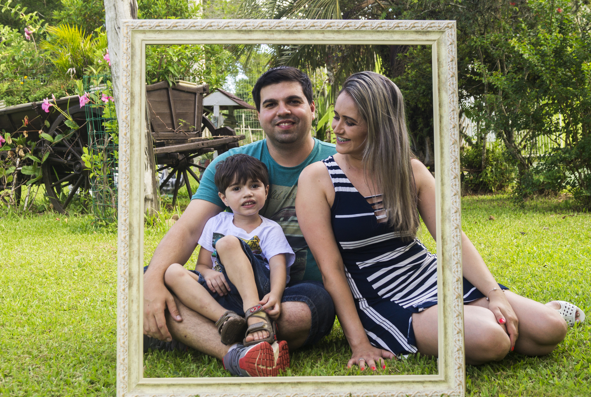 Pai mãe e filho sentados na grama