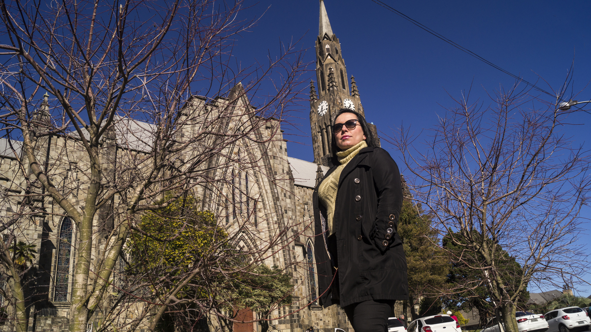 Foto a modelo em primeiro plano com a igreja em Canela em segundo plano