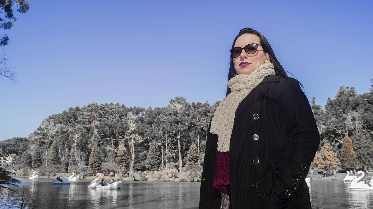 Foto da modelo meio corpo ao fundo o lago negro