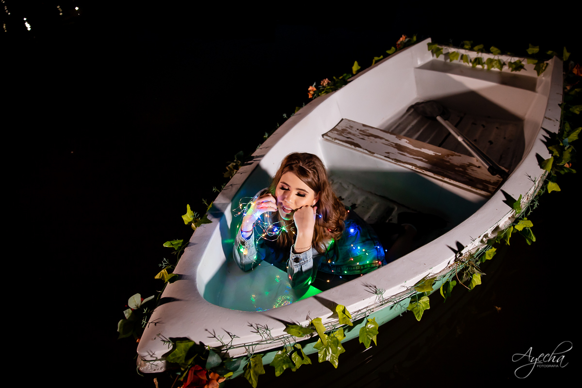 Ensaio 15 anos; Chácara Ienkot; Chácara fotográfica; Inspirações 15 anos; Fotografia 15 anos; Fotografa Curitiba; Fotografa Piraquara; 15 anos Curitiba; Ensaio criativo barco; Ensaio noturno; Ensaio divertido; Fotos com fio de fada colorido; 
