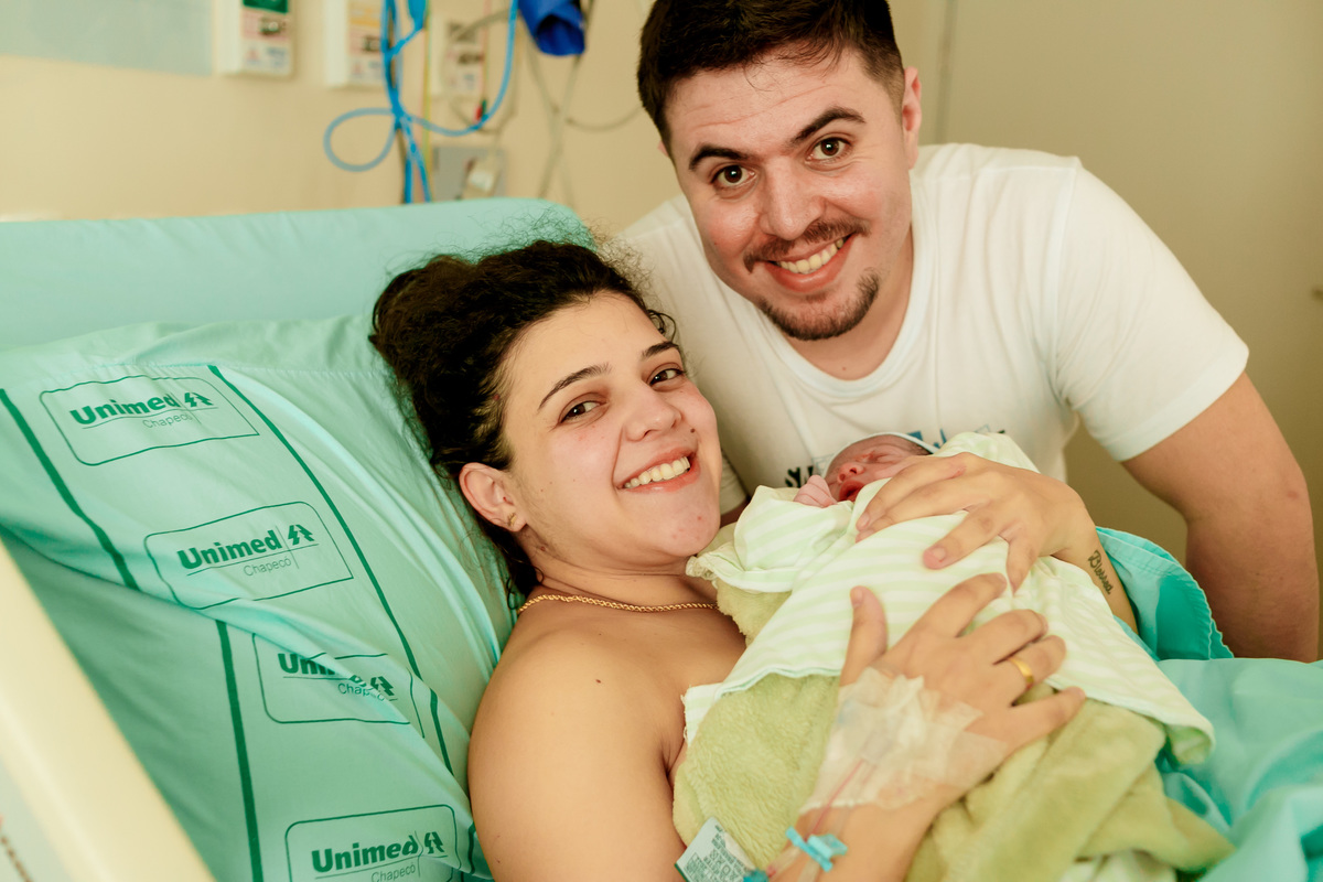 pais com bebe recém nascido no colo