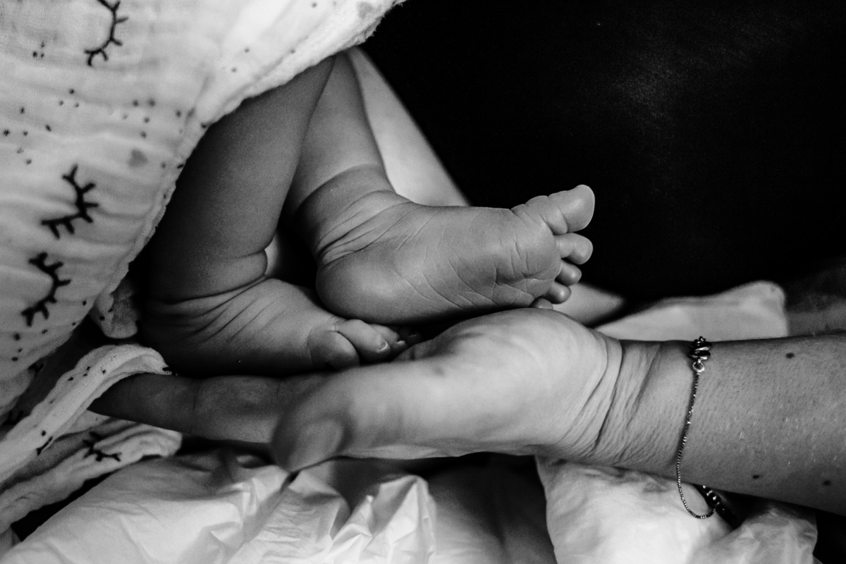 pezinhos de bebê recém nascido na palma da mão
