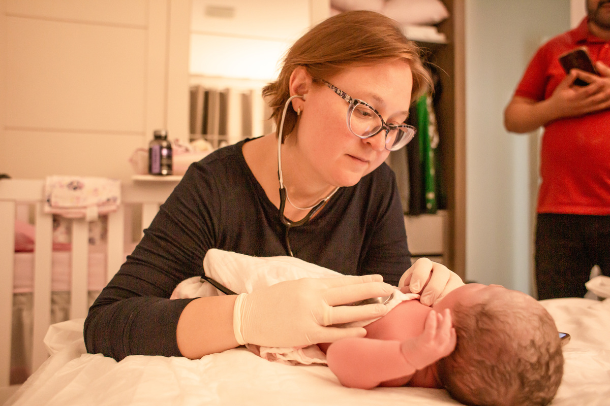 EO examinando o bebê recém nascido