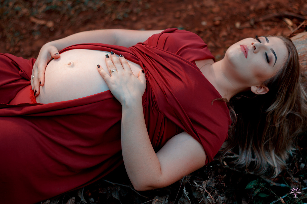 gestante deitada em um tronco
