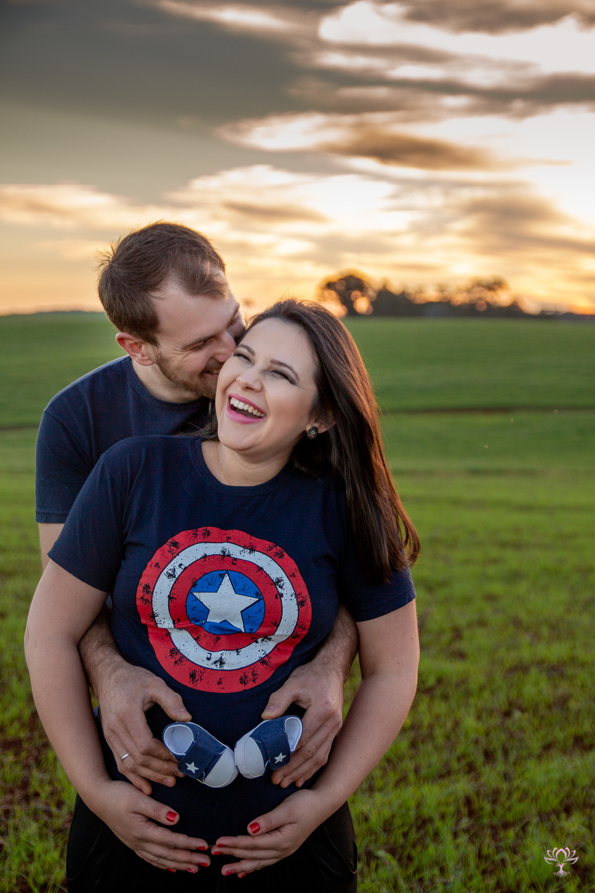 retrato de casal com a mão na barriga da gestante
