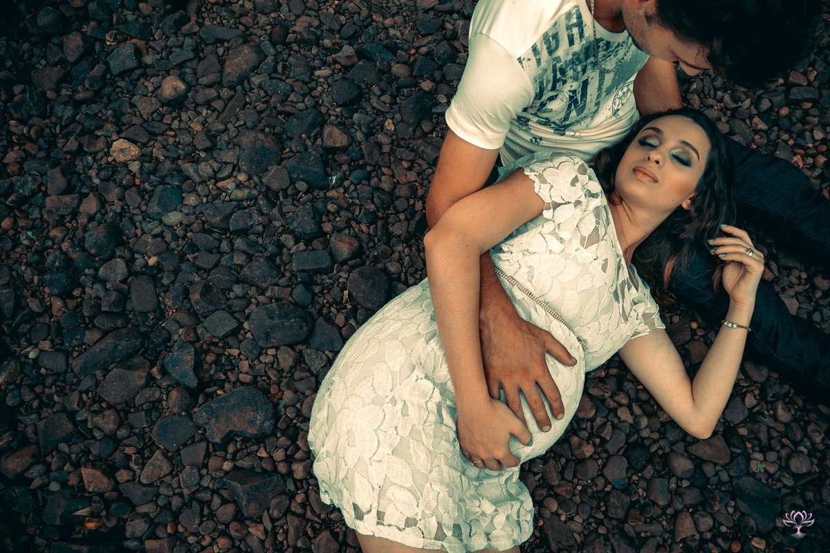 gestante deitada no colo do marido nas pedras