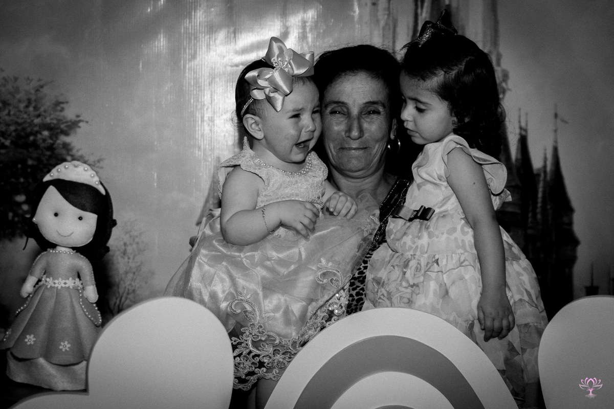vovó com as netinhas no colo no aniversário