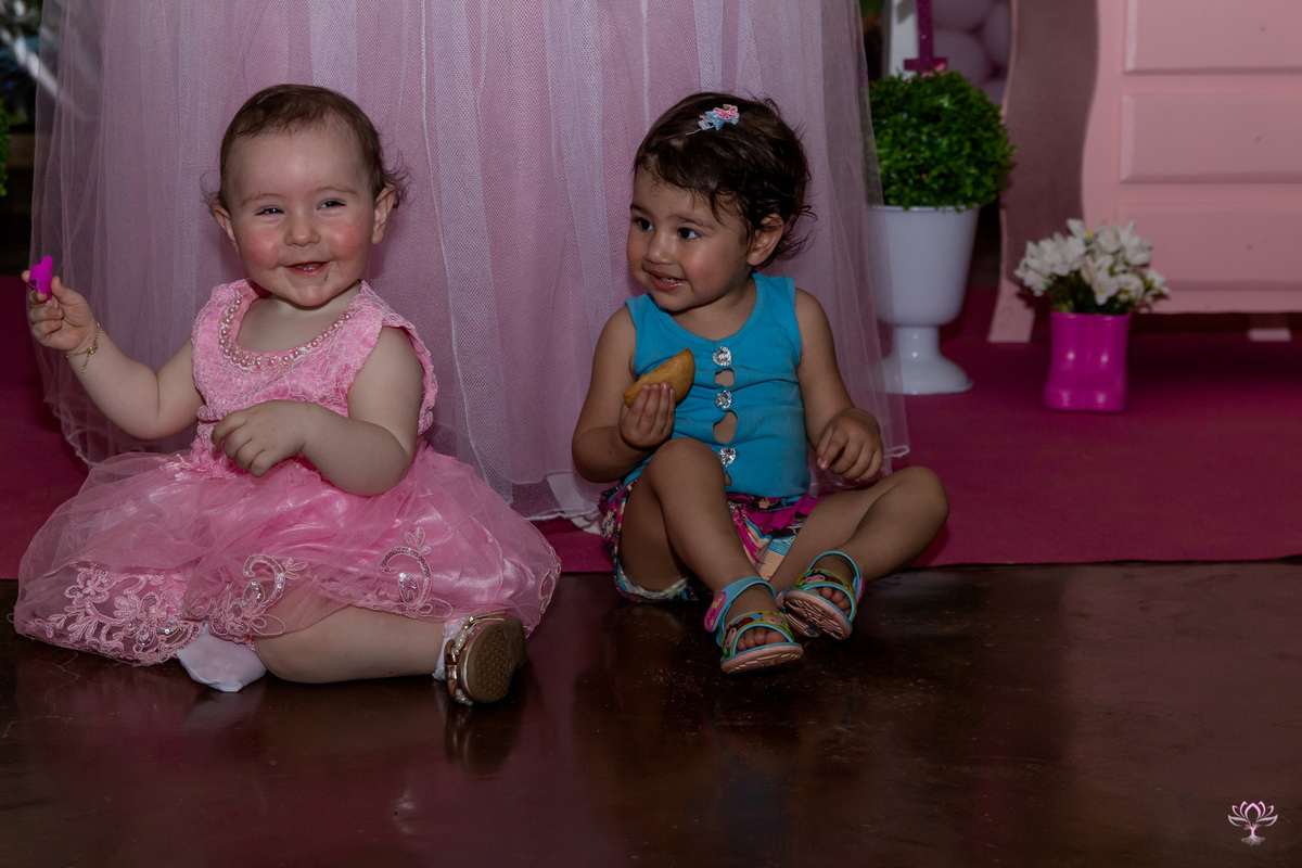 Aniversariante e a amiguinha sentadinhas no chão